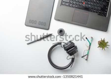 Desktop designer and creative retoucher with a graphics tablet, laptop, glasses. Design, flat lay