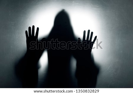 Ghostly figure behind a dusty scratched glass  Royalty-Free Stock Photo #1350832829