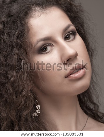 Beauty portrait of a young caucasian woman with long curly hair