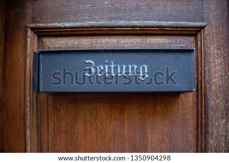 Austrian mailbox at door with the inscription "Zeitung" that means newspaper on wooden door. 
