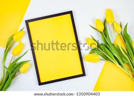 Decorative empty frame with copy space and bouquet of tulips. Greeting card mockup, space for text