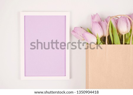 Decorative empty frame with copy space and bouquet of tulips. Greeting card mockup, space for text