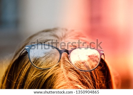 Glasses with rain drops in the girl's hands . Outdoors , Bad eyesight