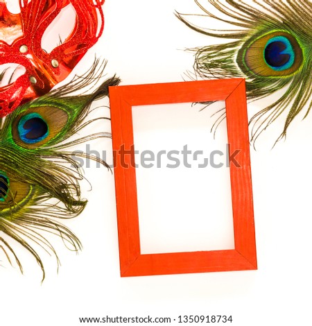 Red empty frame on white background with peacock feather and red glitter carnaval mask