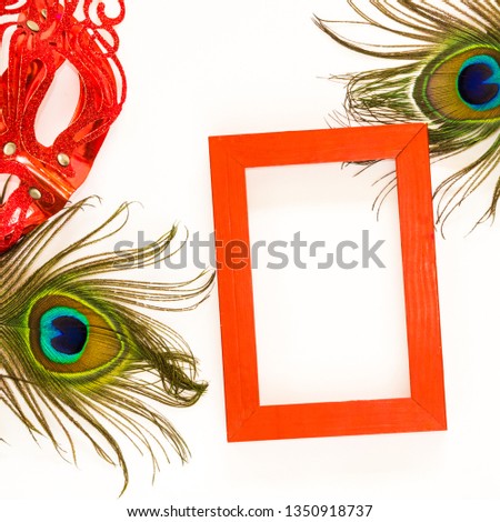 Red empty frame on white background with peacock feather and red glitter carnaval mask