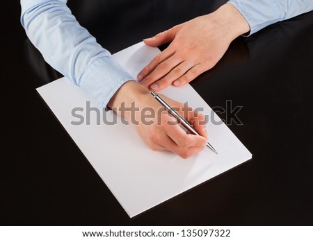 Businesswoman writing down notes on the paper (signing a document)