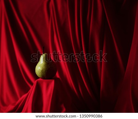 green pear on red background