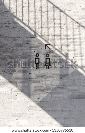 toilet sign on rough concrete wall with beautiful shadow