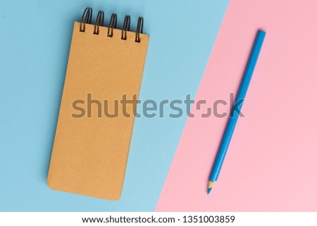 Top view flat lay picture with blank notepad page and pencil on colored surface