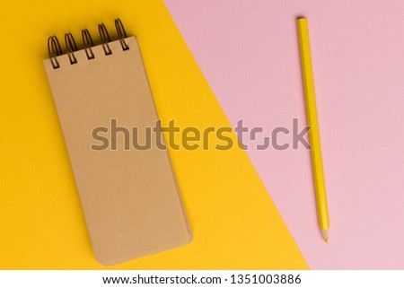 Top view flat lay picture with blank notepad page on colored surface