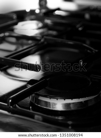 Modern stove cook top in kitchen close-up. Gas burner on a metal stove with control system. Picture of domestic kitchen stove top. Induction coocker, equipment. Tilted composition with artistic noise