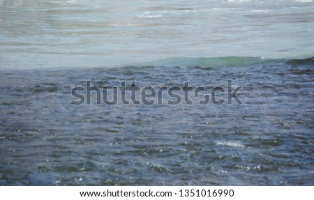 Mountain, transparent river, flowing among smooth stones. River confluence, two different colors