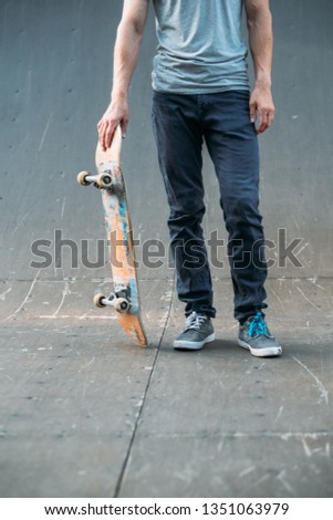 Urban skater. Sport hobby and lifestyle. Man with skateboard. Guy in jeans cropped shot. Skate park ramp. Copy space.