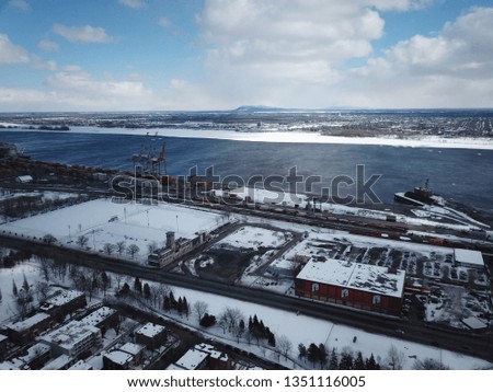 Aerial drone image of Montreal, Quebec from just east of downtown on the island.  It is a cold snowy, sunny winter day.