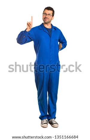 A full-length shot of a Painter man showing and lifting a finger in sign of the best on isolated white background