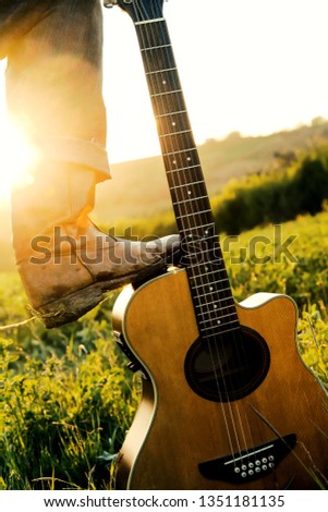 the guitar of the american cowboy at the countryside of Texas on a sunset evening with many different colored sunbeams