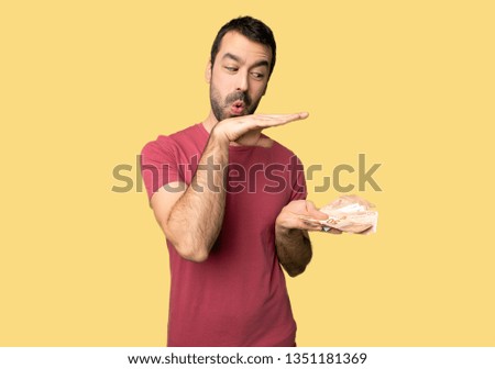 Man taking a lot of money holding copyspace to insert an ad on isolated yellow background