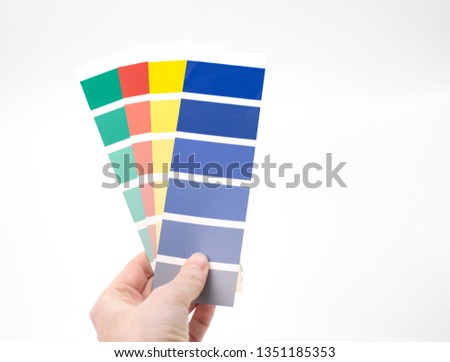 hand holding selection of colour swatches on white background