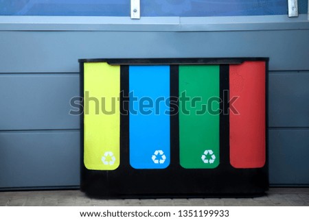 different colored trash containers for garbage separation with sign