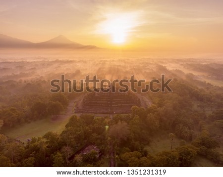 Aerial Shot of Morning Sunrays Penetrate the Mystical Mist Around Borobudur Temple