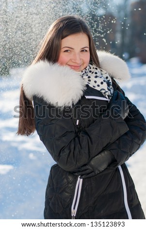 beautiful young smiling woman on the snow outdoors background
