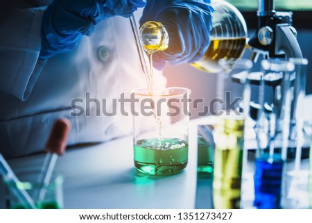  Equipment and science experiments oil pouring scientist with test tube yellow making research in laboratory. Royalty-Free Stock Photo #1351273427
