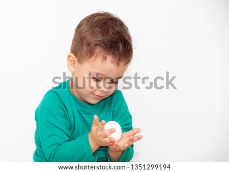 baby with easter egg in hands on white background