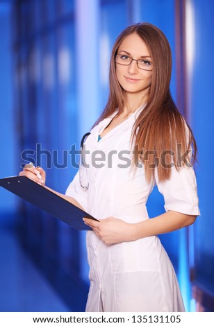 Beautiful young smiling nurse in hospital corridor