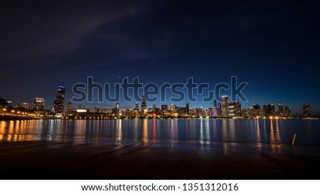 Skyscrapers in Chicago in front of the lake with the colorful illumination