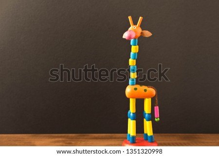 Funny toy giraffe on the wooden table. Empty text space