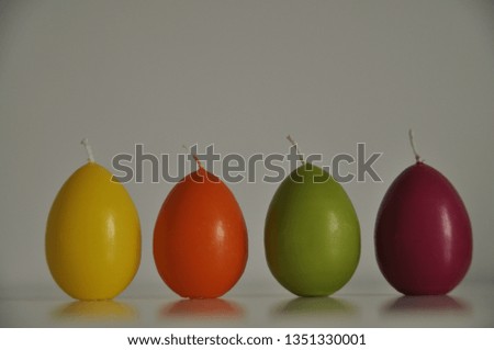 Candles in the shape of eggs on a light background. Easter candle eggs. 