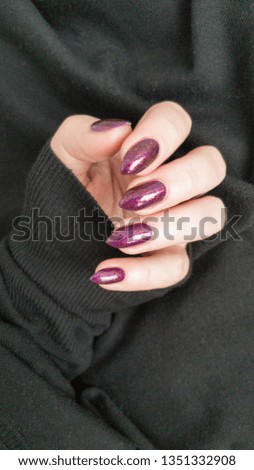 Female hand with black manicure and bottle with nail polish