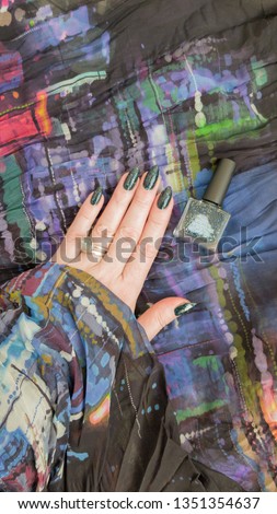 Female hands with long nails with teal green nail polish