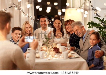 celebration, holidays and people concept - happy family having tea party and photographing by smartphone at home