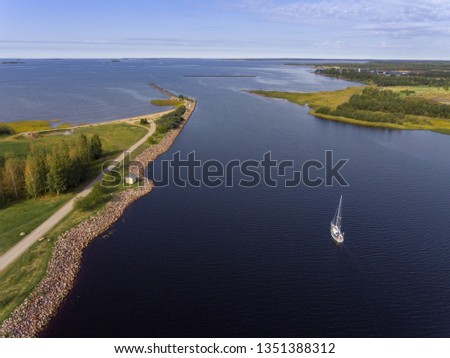 Sail boat making it's way to the open sea. Drone photography. Bird's eye view.