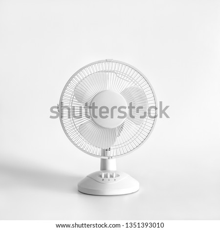 White desktop electric fan on light white background. Minimal concept. Royalty-Free Stock Photo #1351393010