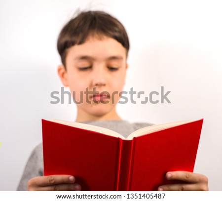 Cute boy reading a red book on white background