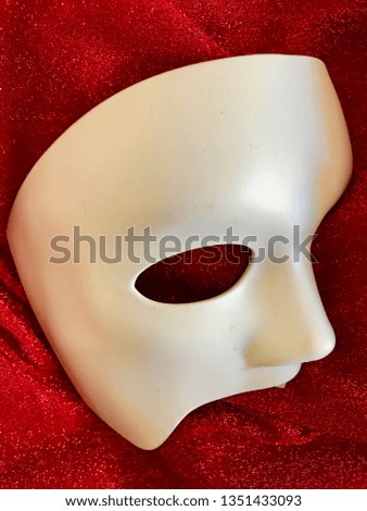 Carnival half-face white mask with red fabric background