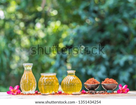 Herbal  organic  essential  oil  in  glass  bottles  on  wooden  surface  with  nature  blurry  background