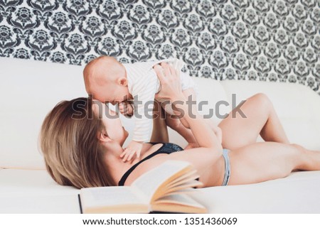A Mother and baby child on a white bed.