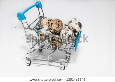 A cart filled with Easter quail eggs on a white background