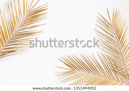 Shiny golden tropical palm leaves closeup border frame isolated on white background. Chic wedding invitation card template. Empty space, room for text.  Royalty-Free Stock Photo #1351494902