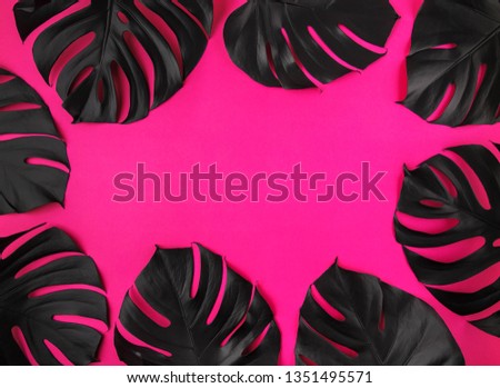 eight black shiny monstera leaves arrangement on plastic pink background. Luxury floral border frame, empty space, room for text, copy, lettering. Trendy artistic club party poster template.