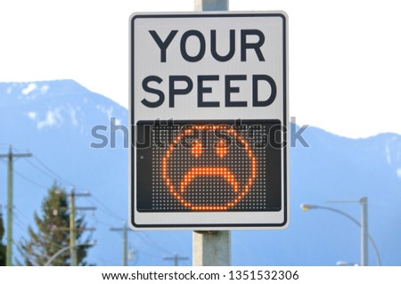 Close on an electronic sign that displays an unhappy face when the motorist or driver is speeding. 