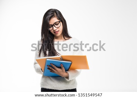 Portrait of attractive asian indian student woman standing holding reading a book with copy space over white background.