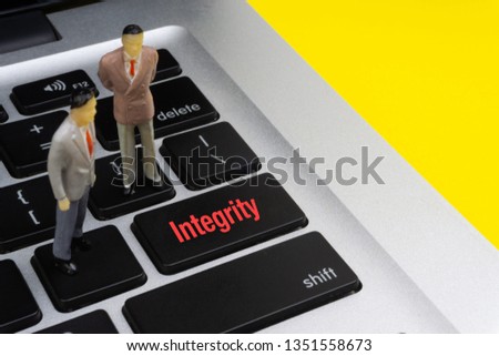 INTEGRITY inscription written words, laptop and businessman miniature. Business and technology concept