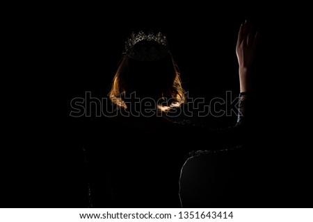 Portrait Silhouette Shadow Back Rim Light of Miss Pageant Beauty Queen Contest Silver Diamond Crown wave hand express feeling smile, studio lighting dark black background, turn back head to camera