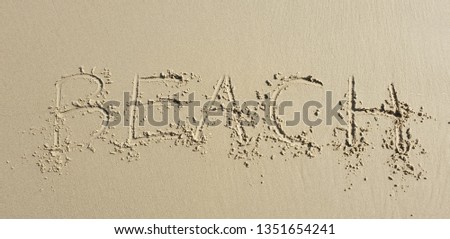 handwriting "beach" on sand beach