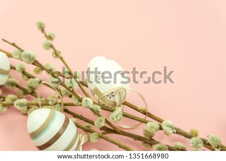Easter holiday concept: Bouquet of willow and easter eggs on pink background with catkins.