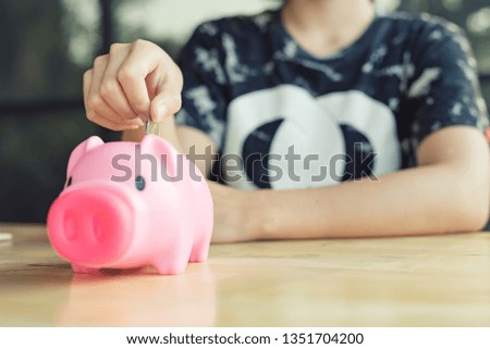 Woman Putting Coin In Piggy Bank, Indoors - Image